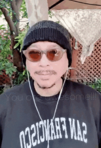 a man wearing sunglasses and a black shirt that says ' you are awesome ' on it