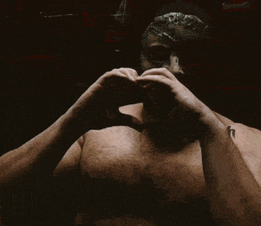 a man making a heart with his hands and the words good night sleep well written on his chest