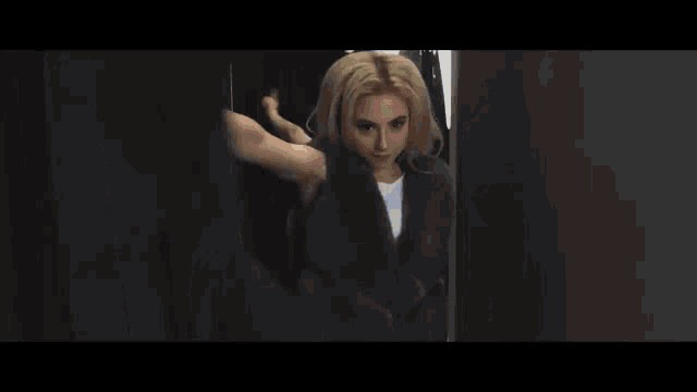 a woman in a blue sweater is standing in a dressing room .