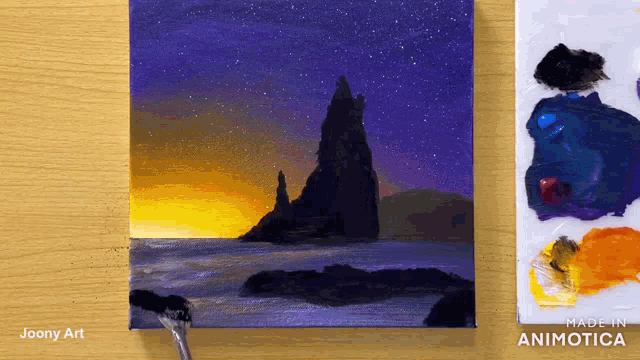 a painting of a sunset by joony art is on a table