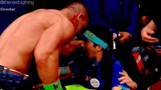 a man without a shirt is kissing another man on the cheek