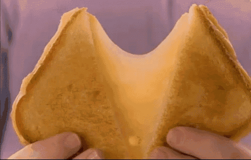 a person is holding a taco with cheese pulled out of it .