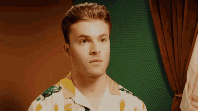 a man wearing a yellow and white shirt with a bug print