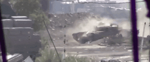 a car is flying through the air in front of a building .