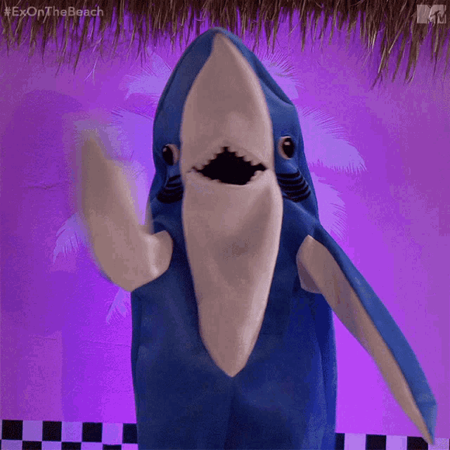 a person in a shark costume with the hashtag #exonthe beach