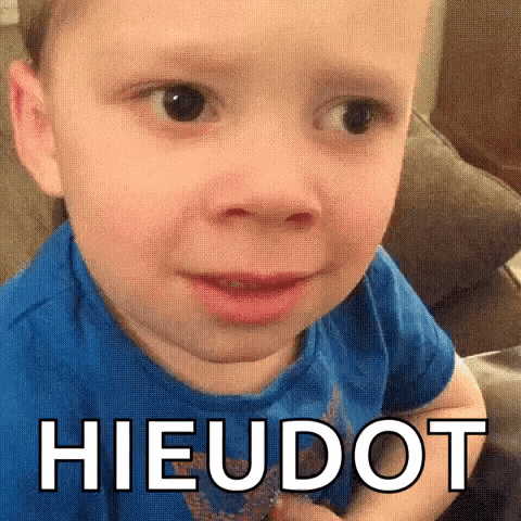 a little boy in a blue shirt is making a funny face and the word hieudot is on the bottom of his face .