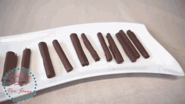 a white plate with chocolate sticks on it with the words por jenny in the corner