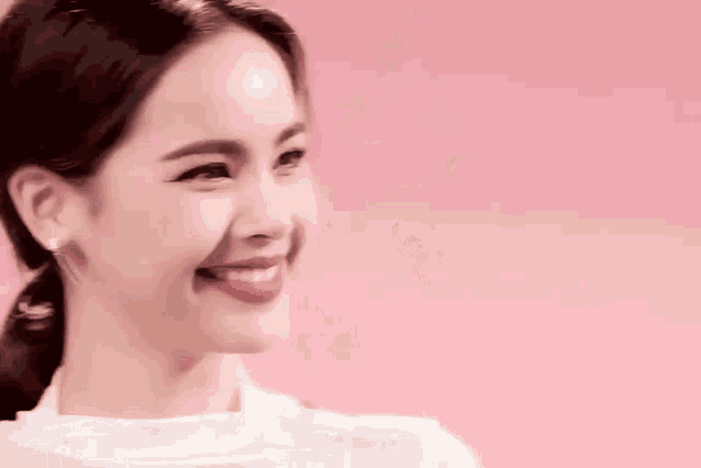 a close up of a woman 's face against a pink background .