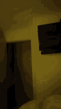 a blurred image of a dark room with a yellow wall