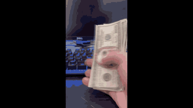 a person is holding a stack of money and a coin with the number 8 on it .