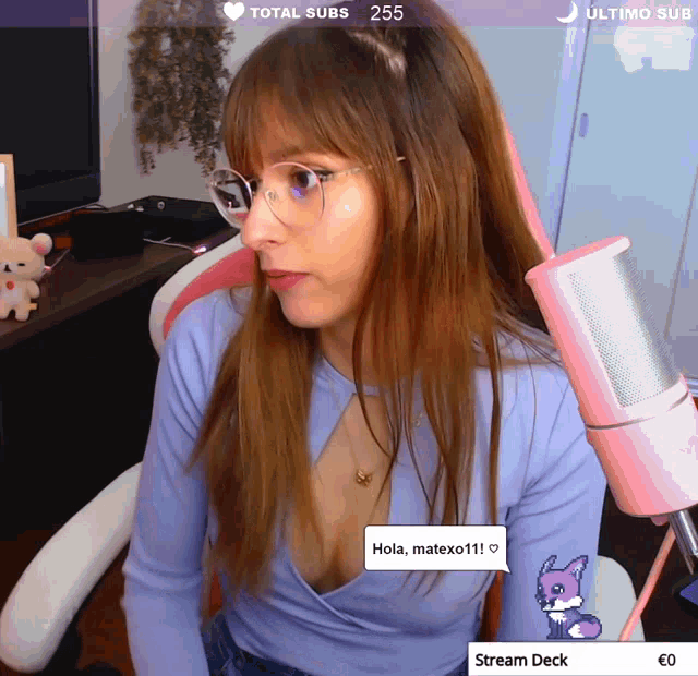 a woman sitting in front of a pink microphone with a speech bubble that says " hola matexo111 "