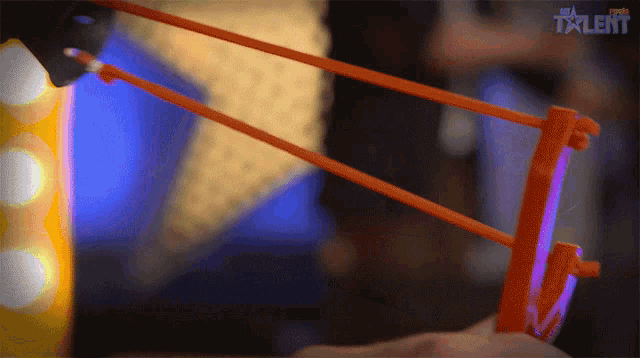a person is holding a slingshot in front of a screen that says the talent