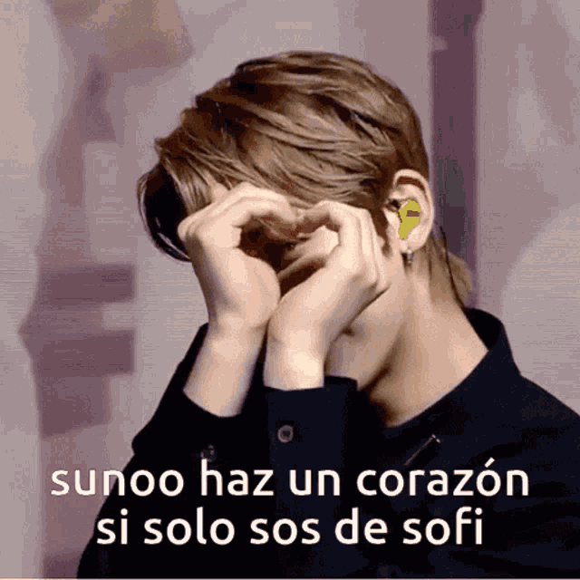 a man covering his face with his hands with the words sunoo haz un corazón si solo sos de sofi below him
