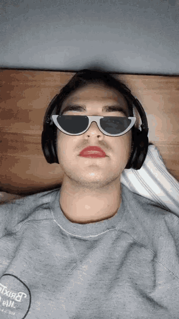 a man wearing sunglasses and headphones is wearing a grey shirt that says texas