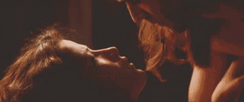 a man and a woman are kissing in the dark .