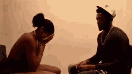 a man and woman are sitting next to each other and the woman is crying .
