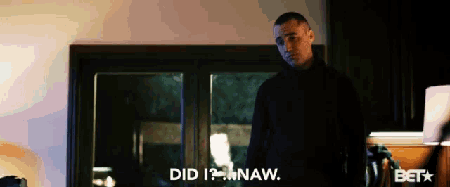 a man in a black shirt is standing in front of a window and says " did i naw "
