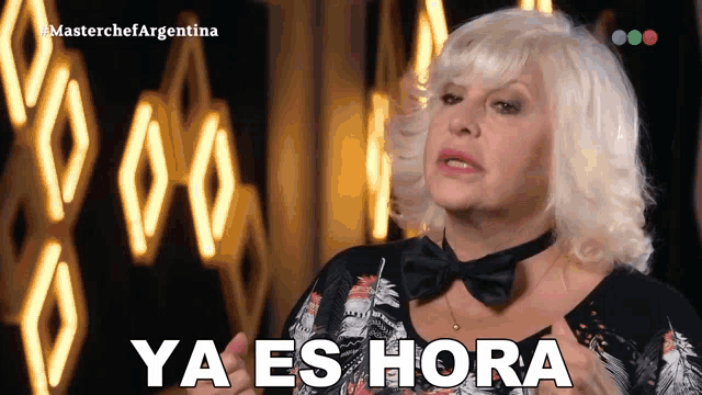 a woman in a bow tie says ya es hora in spanish