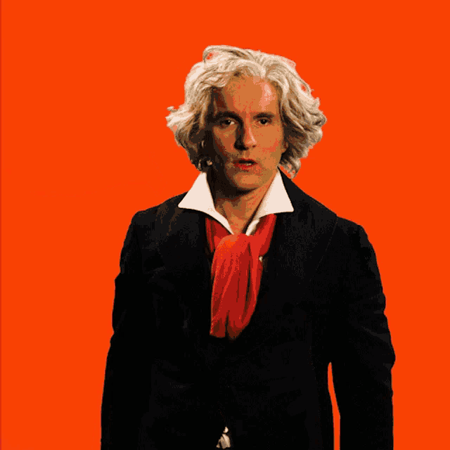 a man with gray hair and a red tie is giving a thumbs up sign