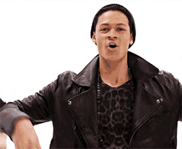 a man wearing a leather jacket and a leopard print shirt is making a funny face