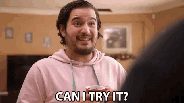 a man in a pink hoodie is asking if he can try it