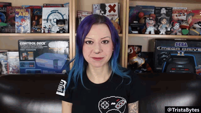 a woman with purple hair is sitting in front of a sega mega drive console