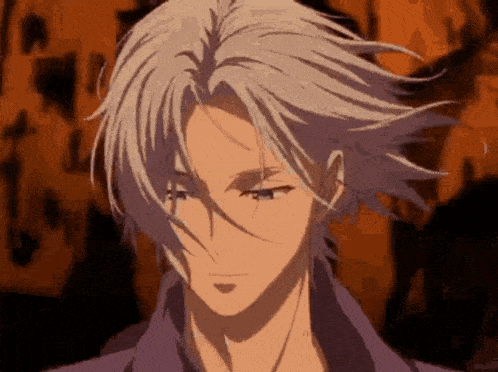 a close up of a person 's face with a purple shirt and gray hair .