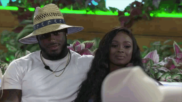 a man wearing a straw hat and a woman wearing a white shirt
