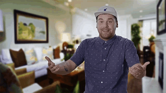 a man wearing a baseball cap and a blue shirt is standing in a living room