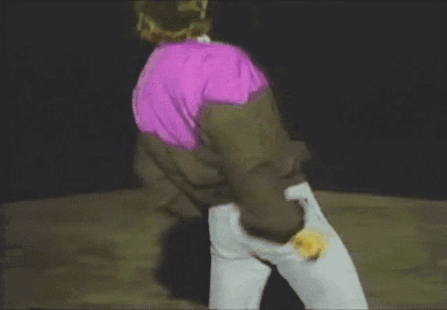 a person wearing a purple and brown jacket and white pants