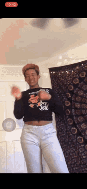 a man wearing a maryland shirt is dancing in a room