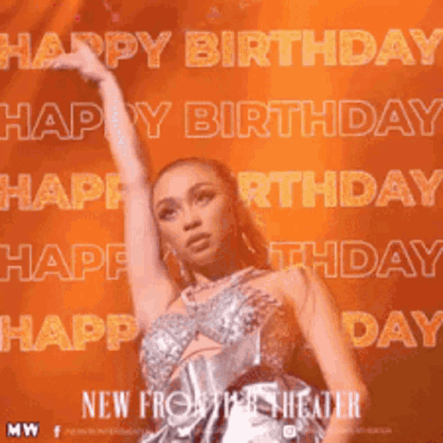 a woman in a silver dress is standing on a stage with her arms in the air and says happy birthday .