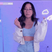 a woman in a white hoodie is standing in front of a blue wall