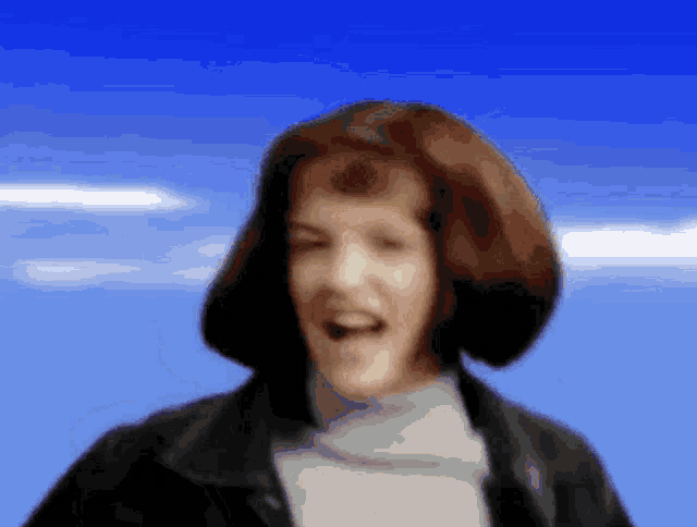a blurry picture of a woman wearing a leather jacket and a turtleneck
