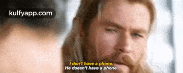 a man with a beard is talking to a woman and says `` i don 't have a phone . ''