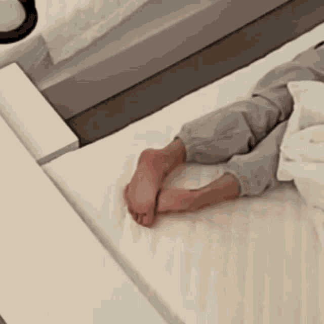 a person is laying on a bed with their legs crossed