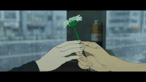 a person is holding a flower with a green stem in their hand