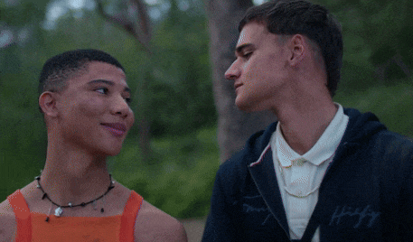 a man wearing a tommy hilfiger sweatshirt looks at another man