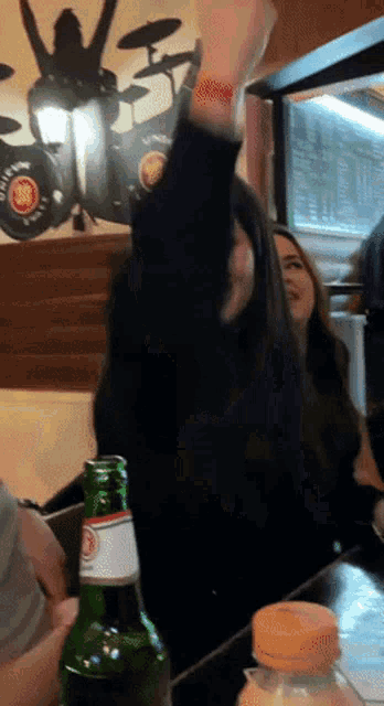a bottle of corona beer sits on a table in front of a group of people