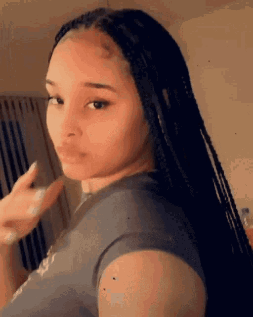 a woman with braids is wearing a gray shirt that says ' i love you ' on the front