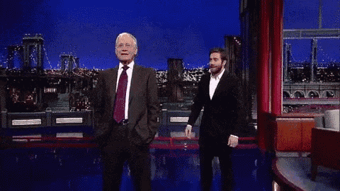 a man in a suit and tie is standing next to another man