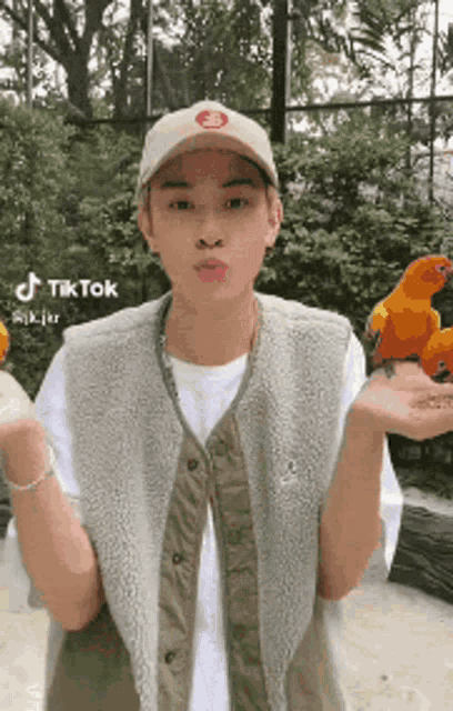 a man is holding two birds in his hands and making a funny face .