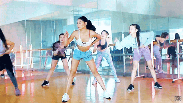 a group of women are dancing in front of a mirror with the letters dsc on the bottom right