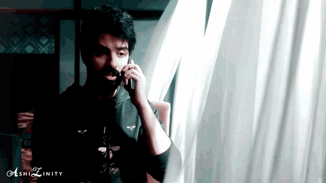 a man is talking on a cell phone with the hashtag ashizfinity