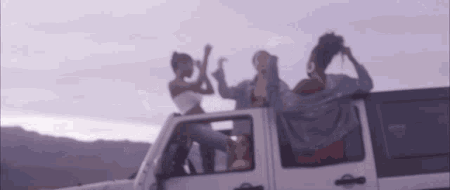 a group of women are sitting in the back of a white car