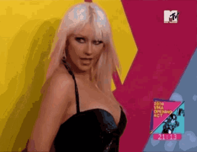a woman is standing in front of a mtv sign