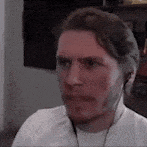 a man wearing headphones is making a funny face while looking at the camera .