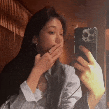 a woman is taking a picture of herself in a mirror .