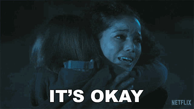 a woman hugging another woman with the words " it 's okay " written below her