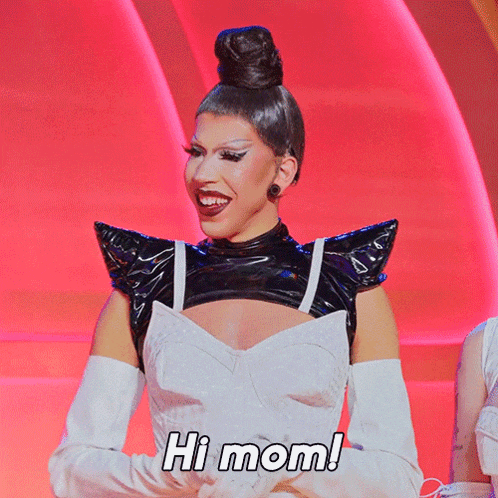 a woman wearing a black top and white gloves is smiling and says hi mom